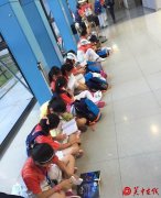 西安小学生机场席地而坐安静读书有序等安检获